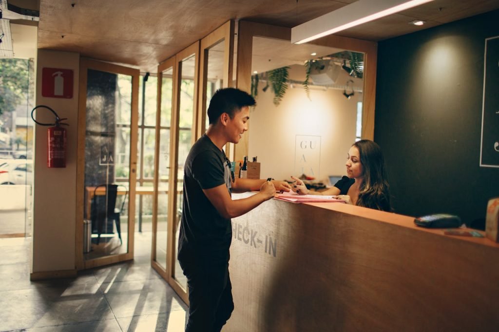 A front desk attendant assisting a customer