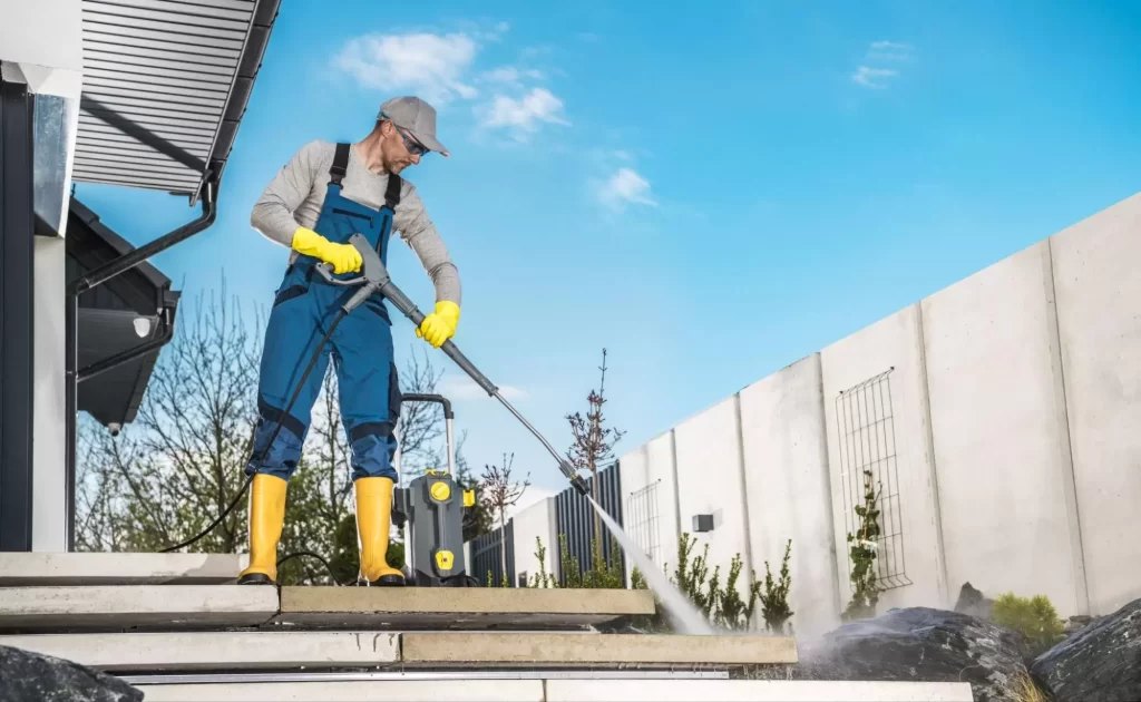 Man pressure washing an outdoor brick walkway