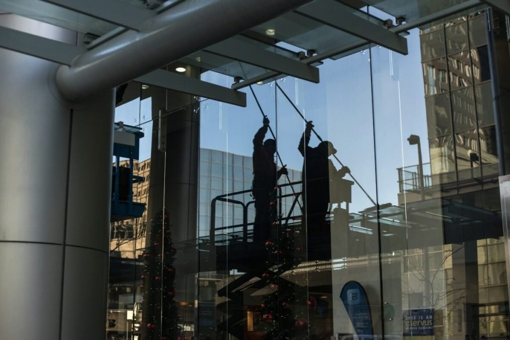 Two men washing tall windows