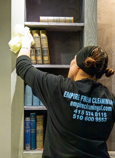 man cleaning bookshelf