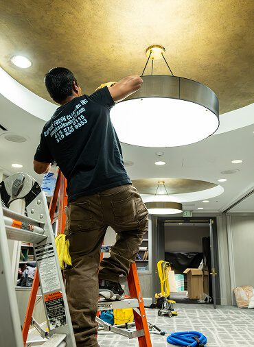 man cleaning cealing light