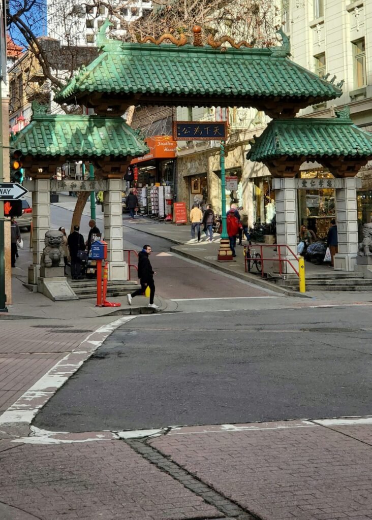 A man is walking by the entrance to San Francisco’s Chinatown